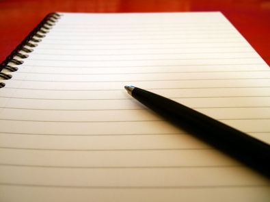 A pen rests on a blank pad of writing paper - perfect for sharing your reflections, thoughts, and feelings.